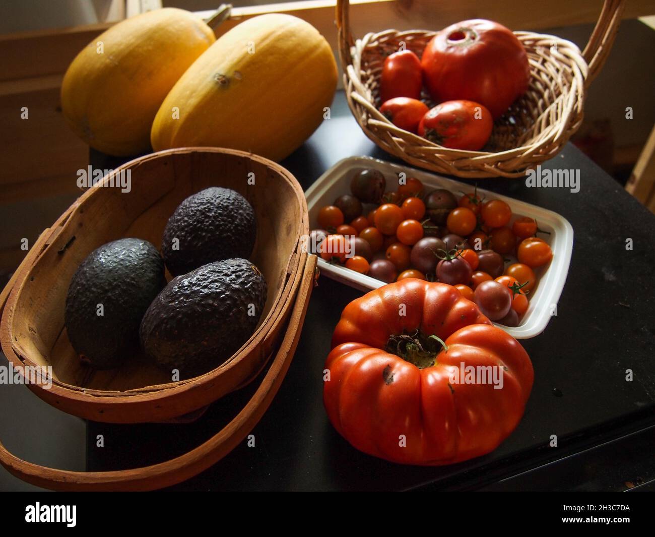 Ortaggi da giardino freschi, pomodori, zucca, e avocado, USA, 2021 © Katharine Andriotis Foto Stock