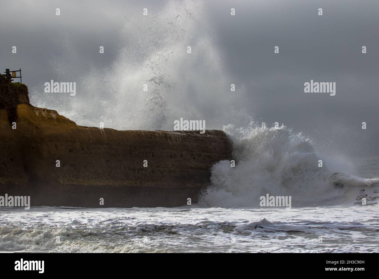 Onda che si schiantano in un promontorio costiero roccioso durante una tempesta a Blacks Beach, Santa Cruz, California Foto Stock