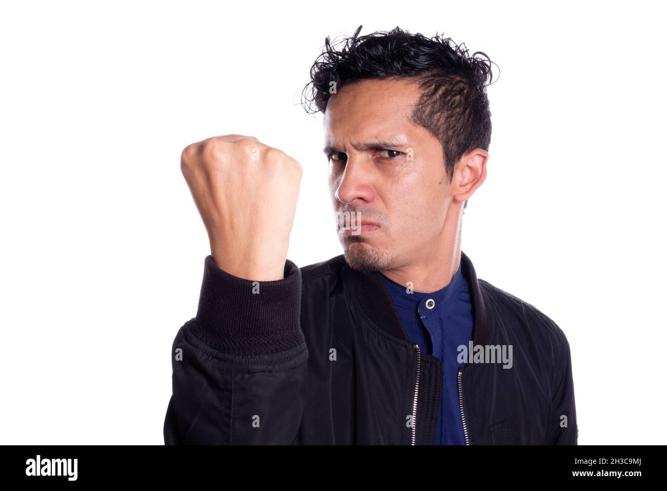 Uomo arrabbiato con desiderio di pugno di pugno, isolato su sfondo bianco. Giovane adulto che mostra e stringe il pugno alla macchina fotografica. Foto Stock