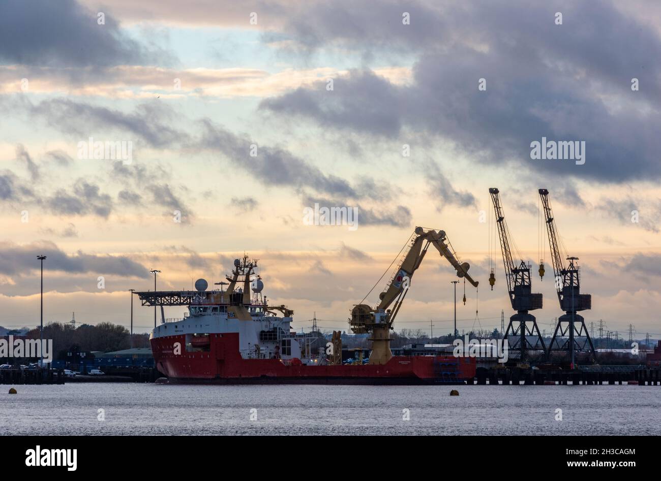 tramonto su marchwood porto militare e gru sul bordo del porto di southampton banchine, uk. dockyard gru, flotta reale navi ausiliarie, esercito. Foto Stock