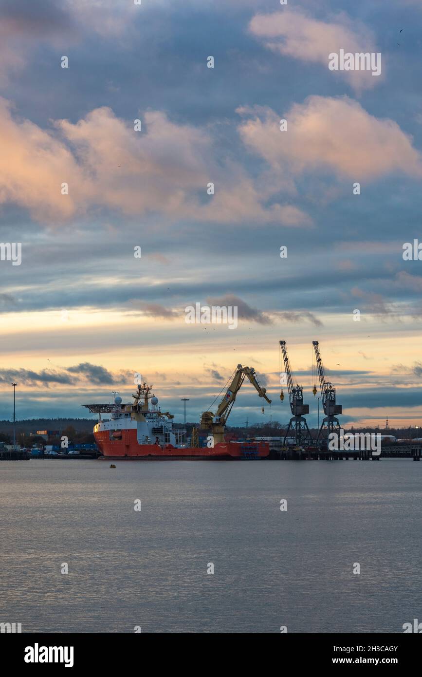 tramonto su marchwood porto militare e gru sul bordo del porto di southampton banchine, uk. dockyard gru, flotta reale navi ausiliarie, esercito. Foto Stock