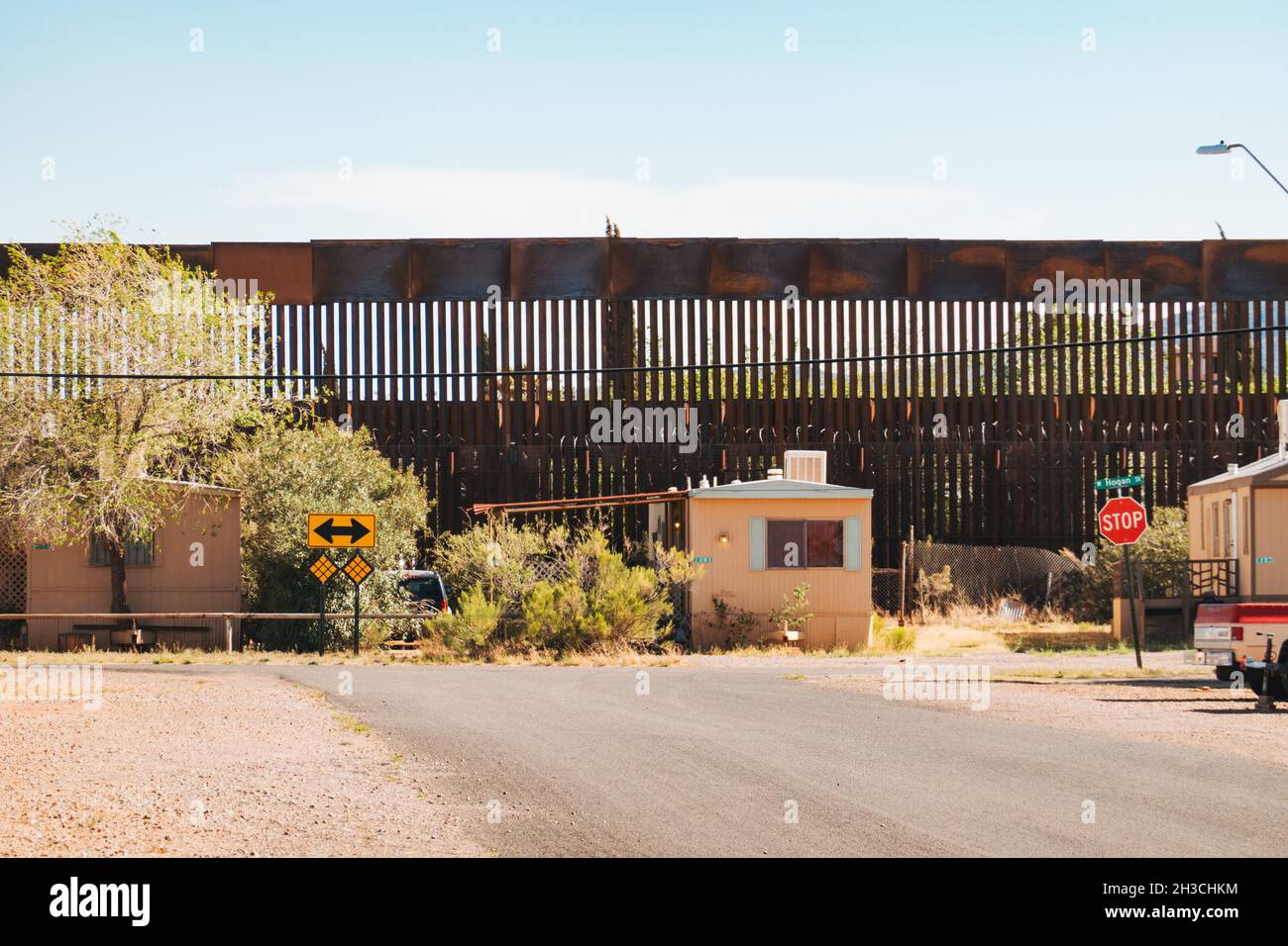 Guardando giù una strada suburbana verso la barriera Messico-Stati Uniti, nella città di confine di Naco, Arizona Foto Stock