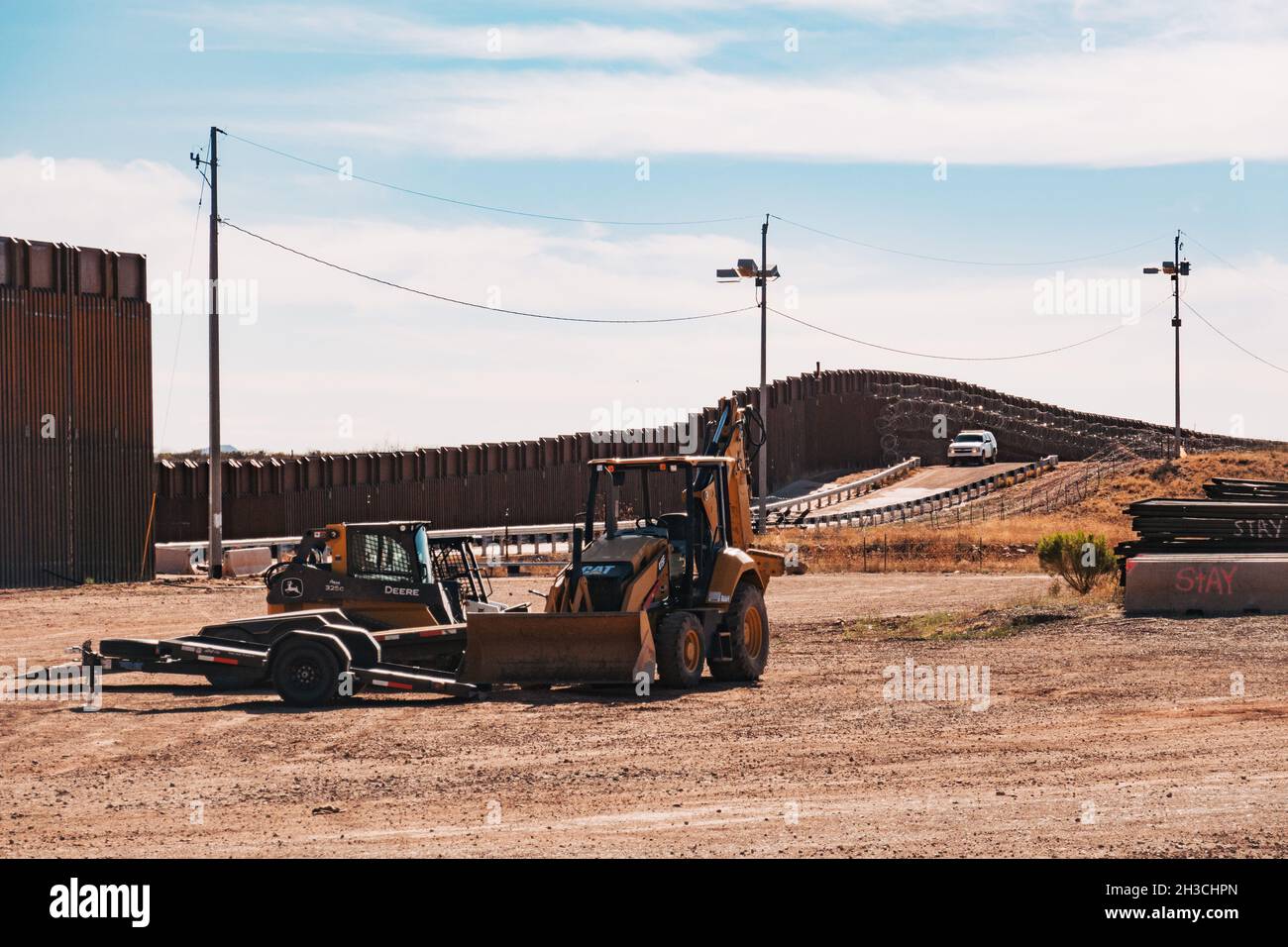 Attrezzature da costruzione presso il muro di confine USA-Messico a Naco, Arizona. Un veicolo Border Patrol controlla il muro Foto Stock