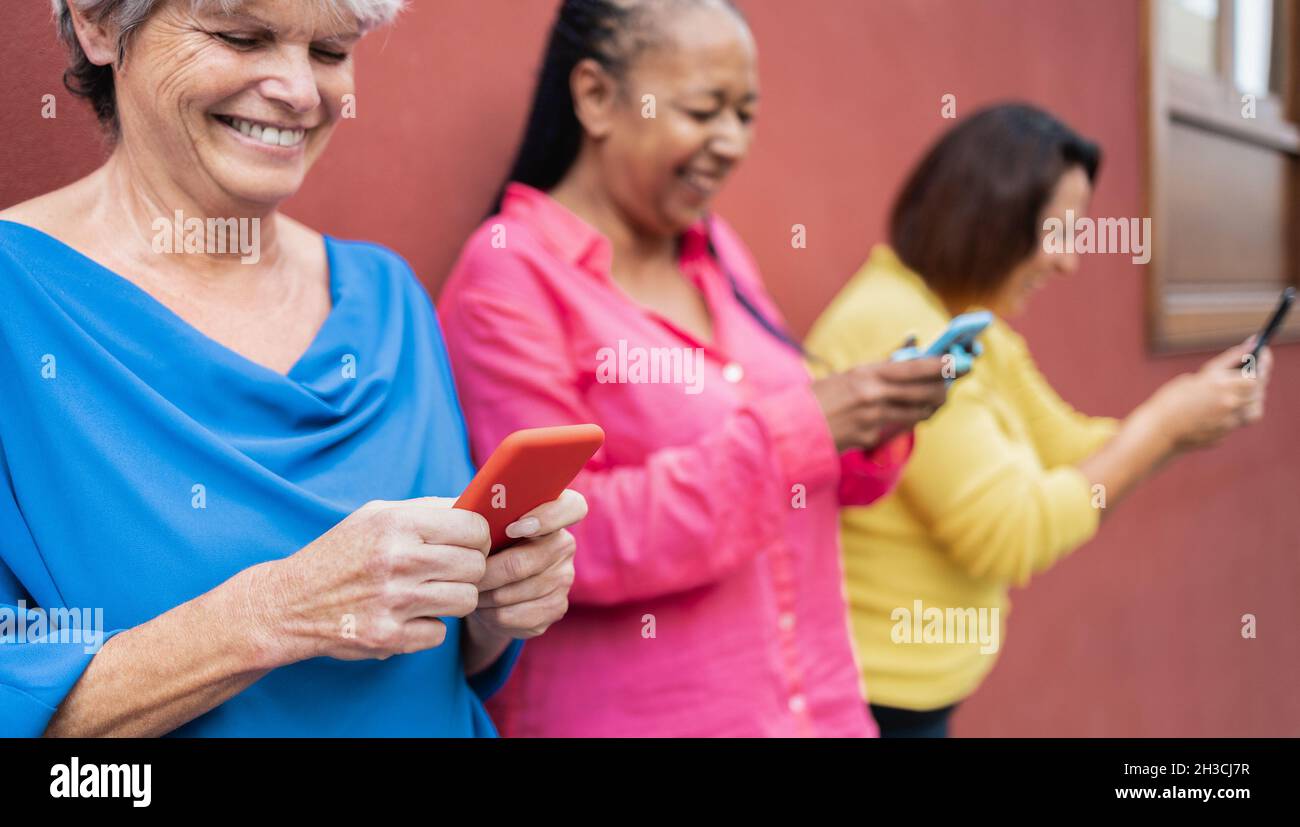 Persone anziane felici che utilizzano telefoni cellulari outdoor - concetto di tecnologia di stile di vita anziano Foto Stock