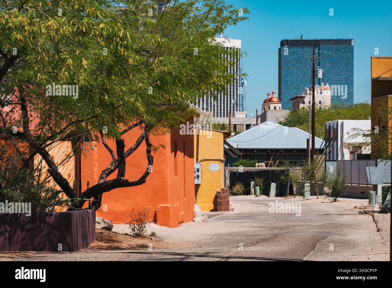 Case in adobe dipinte con colori vivaci di Barrio Viejo, vista contro i moderni grattacieli del centro di Tucson, AZ Foto Stock