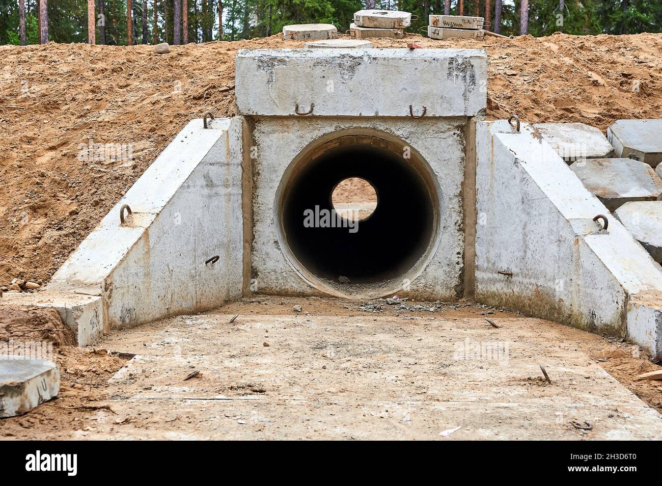 tubo di calcestruzzo sotto la strada per drenaggio di acqua Foto Stock