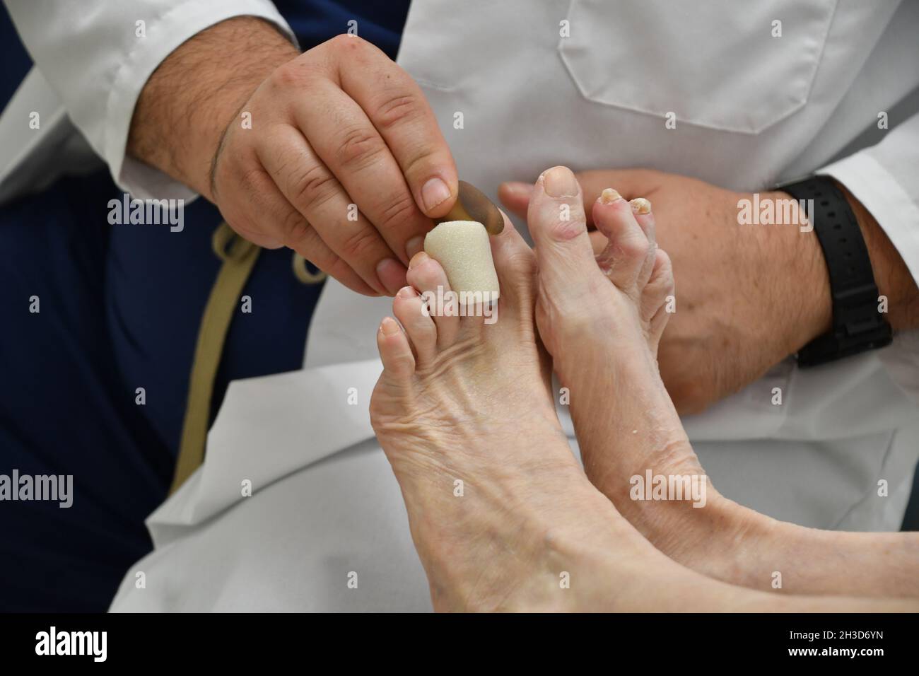 Visita del medico podiatristo geriatrico femminile Foto Stock