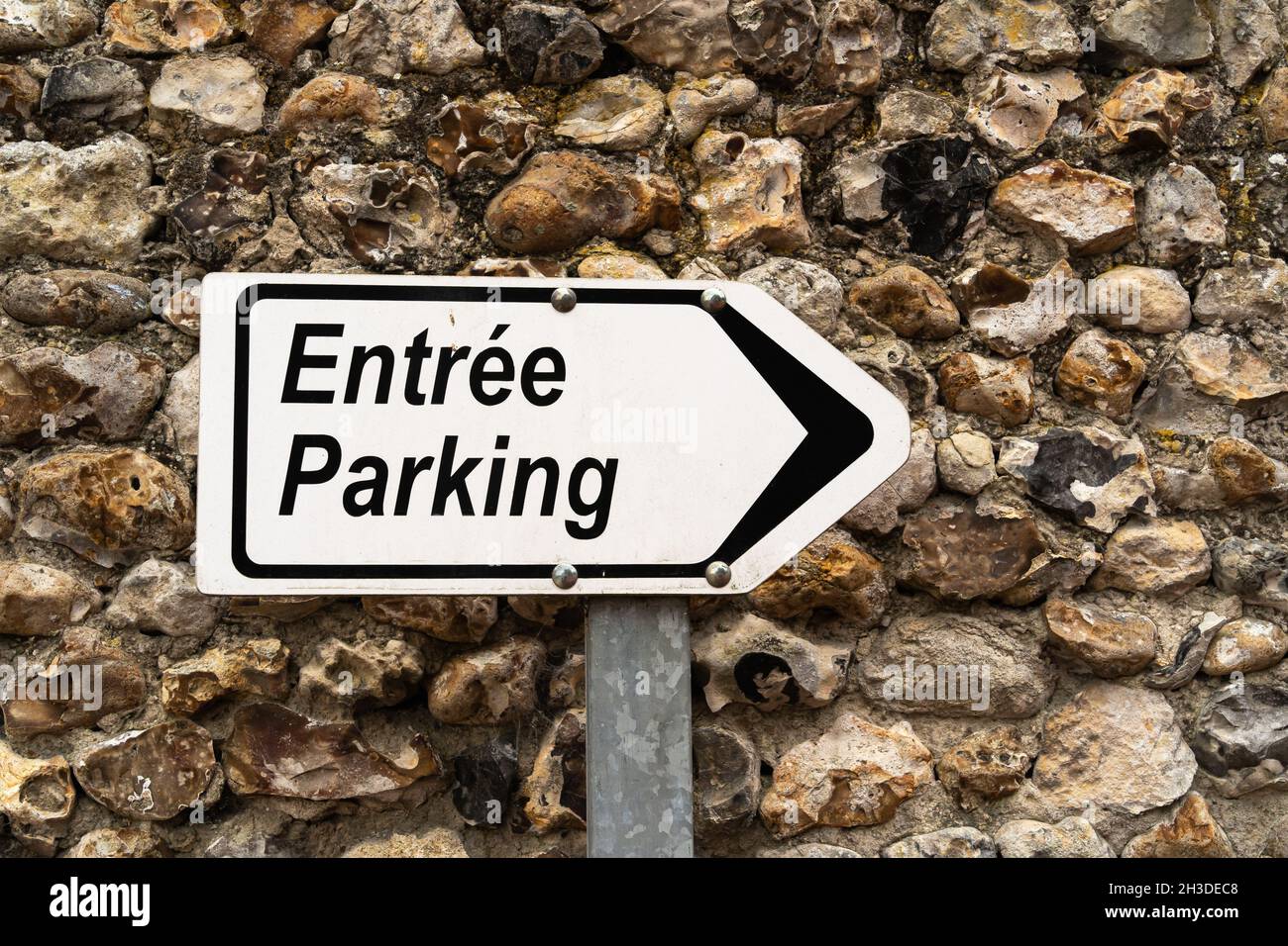 Freccia con un cartello in francese che indica la direzione dell'ingresso del parcheggio Foto Stock