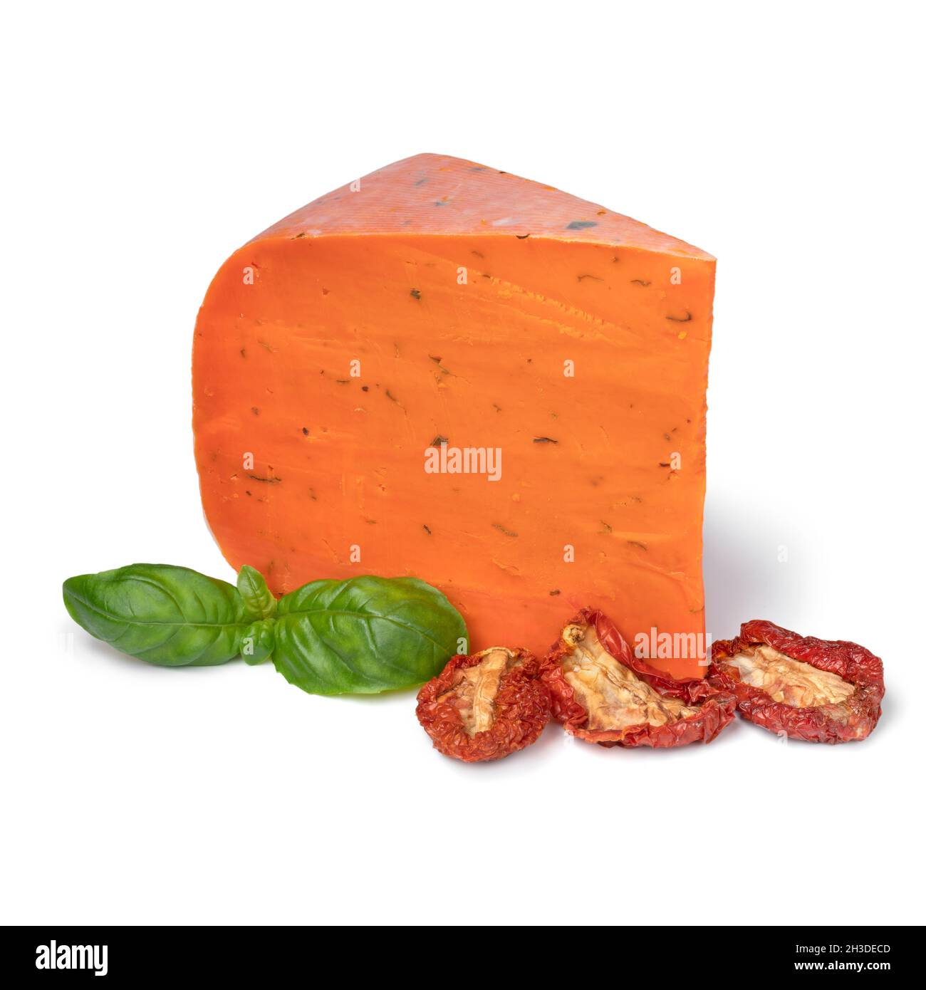 Pezzo di pomodoro essiccato al sole e foglie di basilico isolato su sfondo bianco Foto Stock