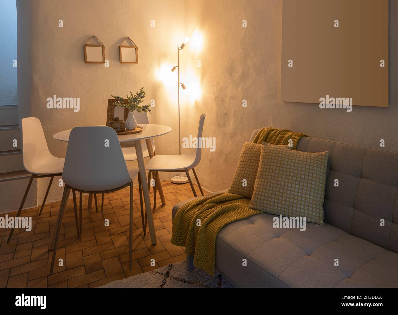 Moderno soggiorno di una casa di montagna con un tavolo, quattro sedie di design e un comodo divano con una coperta. Nessuno dentro Foto Stock