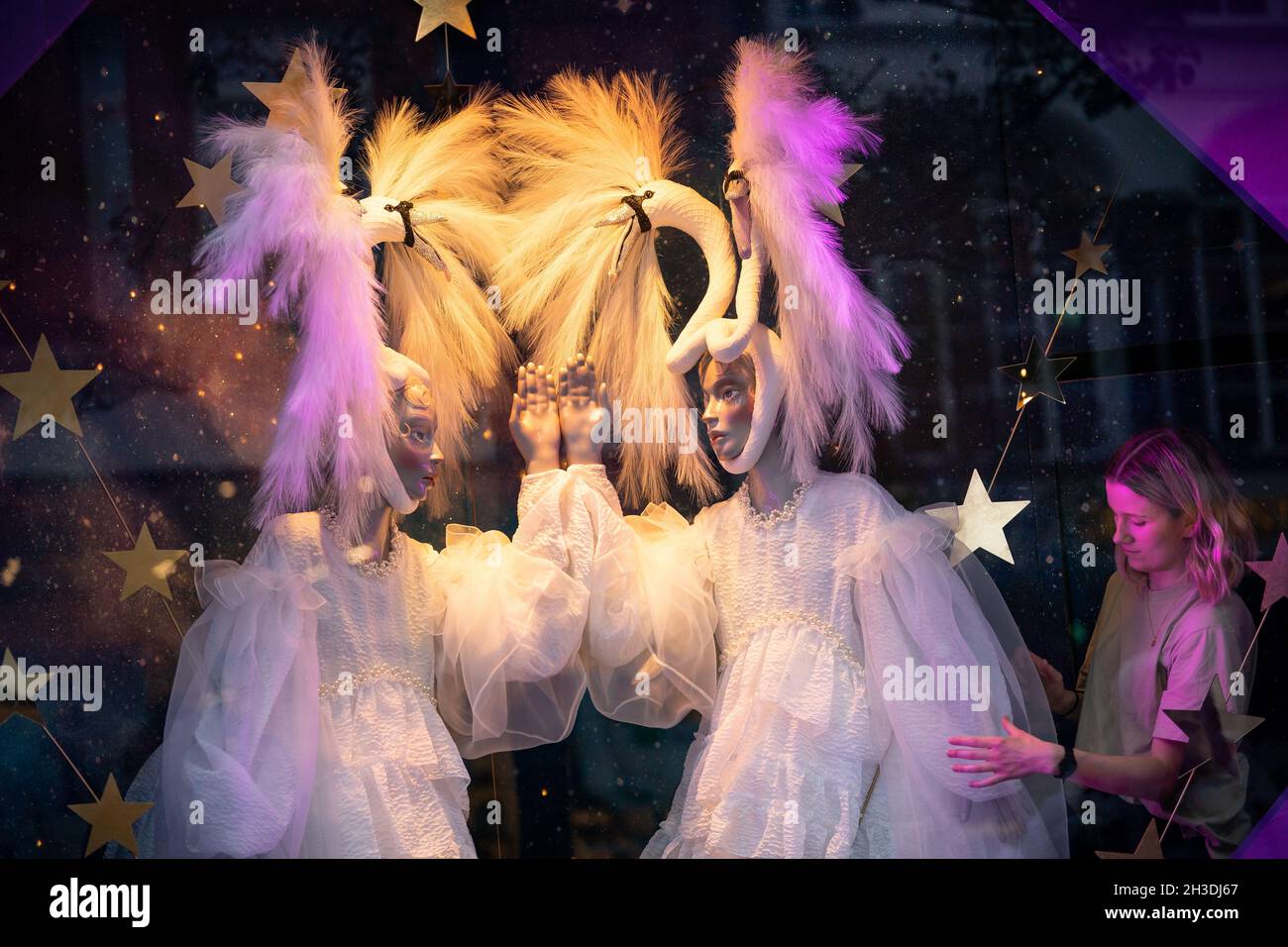 Un assistente di negozio regola una vetrina a Selfridges a Londra mentre il grande magazzino svela le sue finestre di Natale su Oxford Street. L'esposizione di quest'anno è dedicata al "Natale dei sogni". Data foto: Giovedì 28 ottobre 2021. Foto Stock