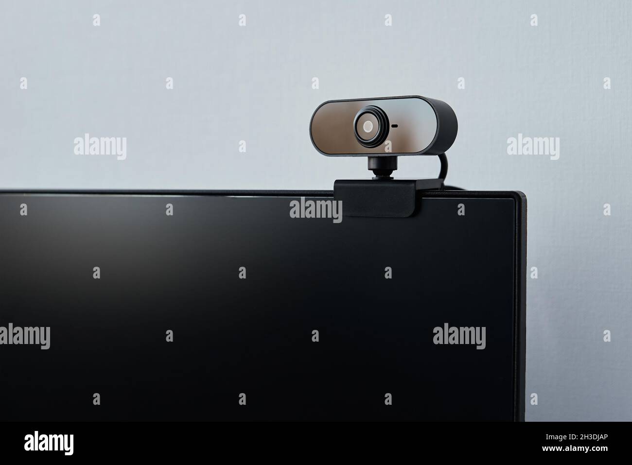 Webcam sopra lo schermo del computer. Webcam nera sopra lo schermo nero. Concetto di sicurezza digitale Foto Stock