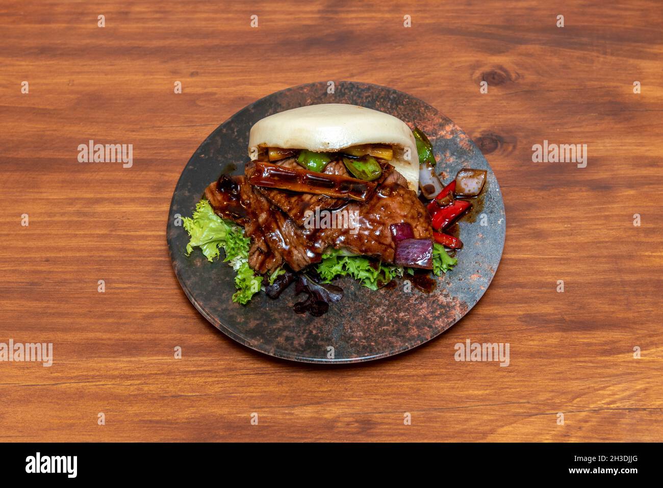 Pane di Bao ripieno di stufato di manzo con bambù, peperoni e cipolla Foto Stock