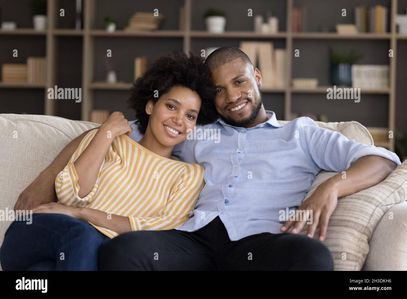 Sorridente bonding misto coppia gara poggiante sul divano. Foto Stock