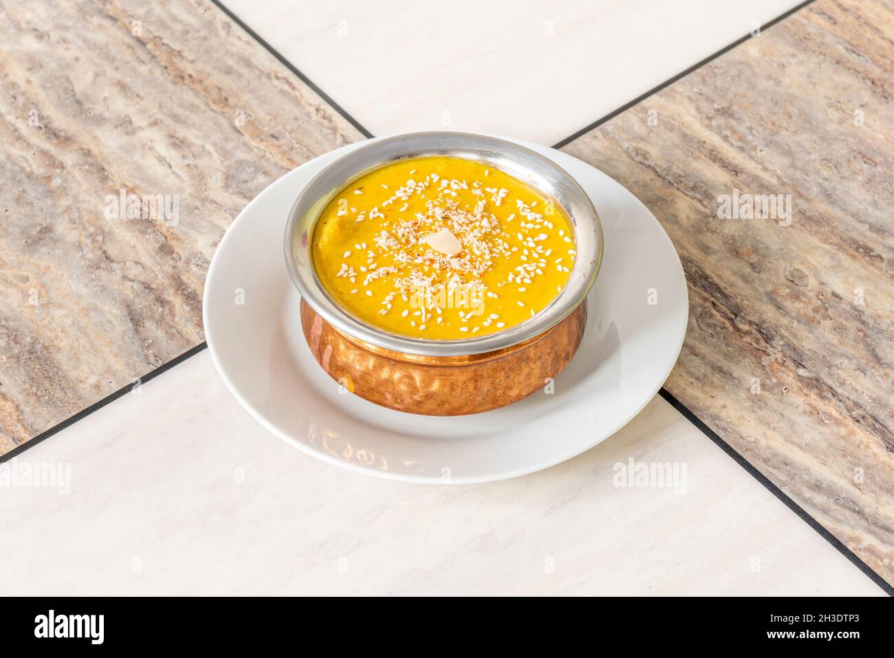Curry korma di pollo delicato con semi di sesamo e mandorle tritate su una ciotola di metallo in un ristorante indù Foto Stock