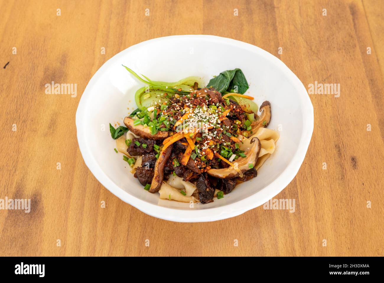 Ramen di manzo secco con collardi, funghi asiatici, carote, pasta di riso e erba cipollina con semi di sesamo Foto Stock