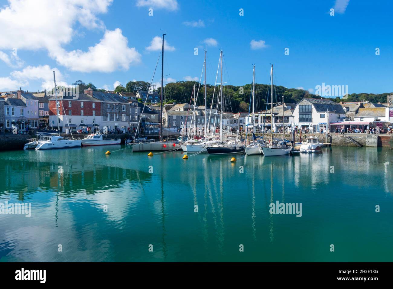 Una bella giornata di sole nel villaggio di Padstow, Cornovaglia, Inghilterra, Regno Unito causando i riflessi delle barche nel porto acqua sottostante Foto Stock