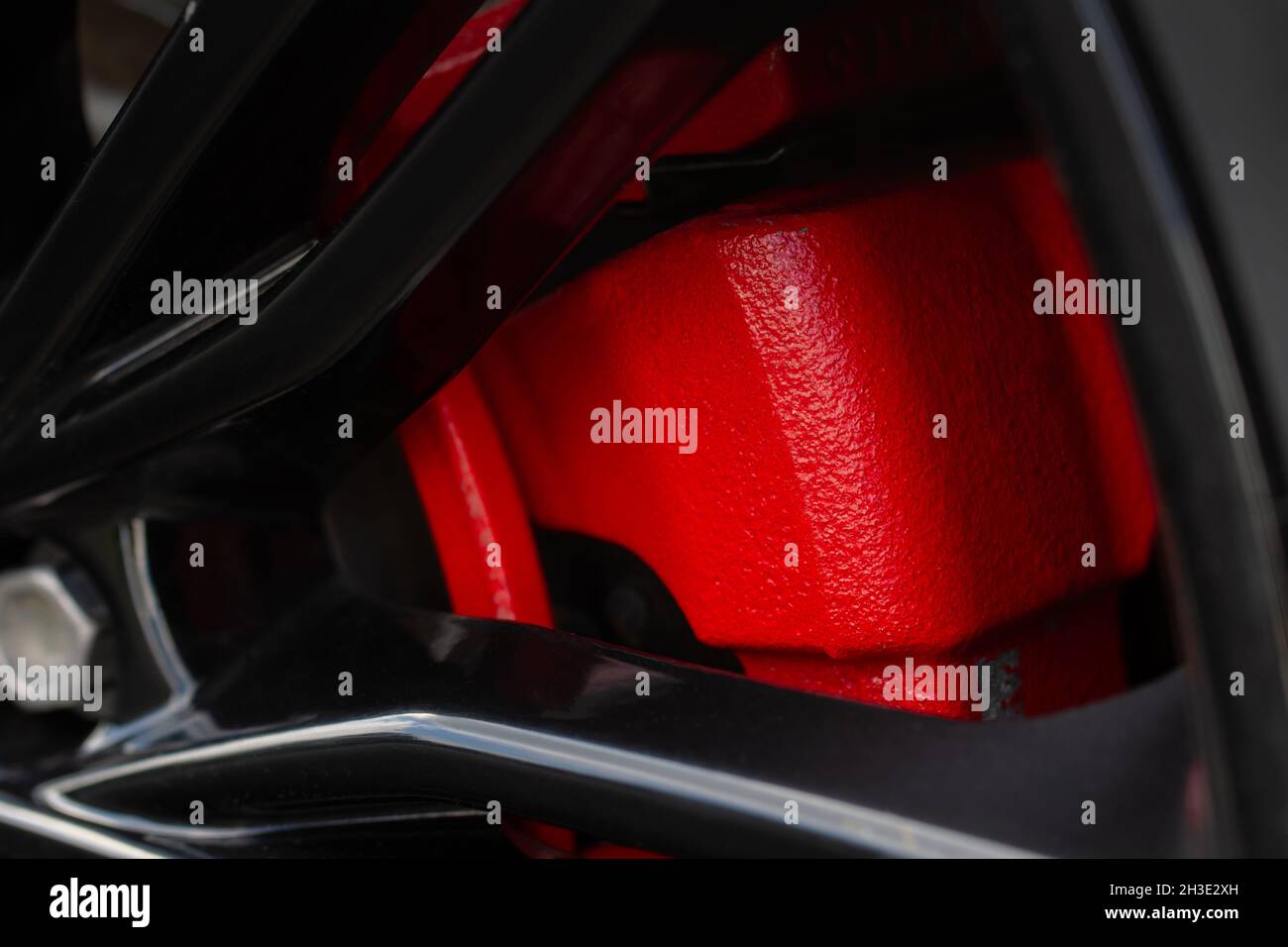 Primo piano di una ruota moderna con freno a disco rosso. Vista ravvicinata dei freni dell'auto. Pulire il freno a disco dell'auto. Foto Stock
