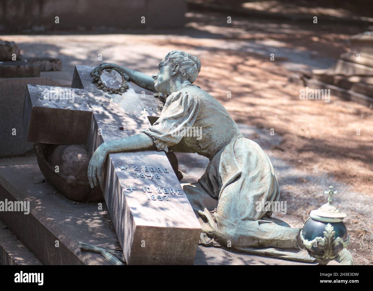 la vedova piange il marito defunto, vecchia statua di bronzo in un cimitero Foto Stock