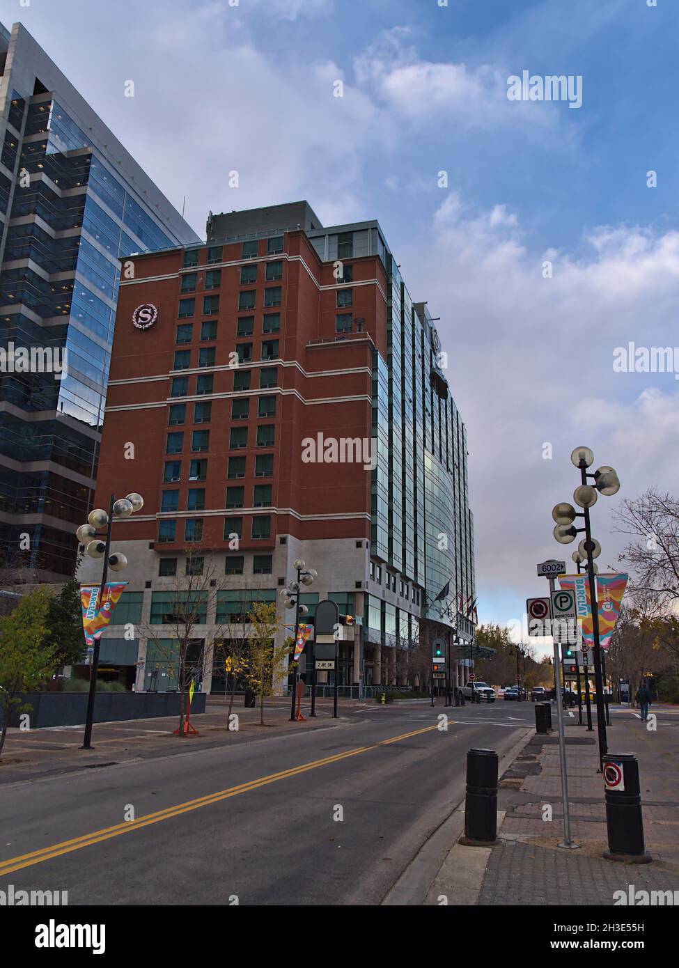 Vista dell'hotel Sheraton Suites Calgary Eau Claire gestito da Marriott International Inc. In centro con strada vuota alla luce della sera in autunno. Foto Stock