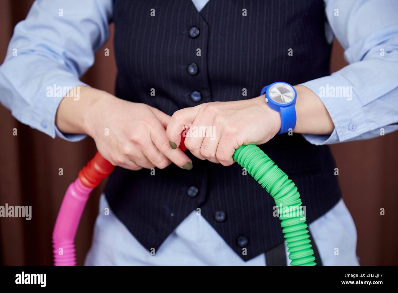 Lo psicologo infantile mostra una nuova tendenza nel giocattolo Pop tube. Colorato popolare giocattolo anti-stress sensoriale. Giocattolo antistress alla moda per lo sviluppo di belle abilità motorie. Foto di alta qualità Foto Stock