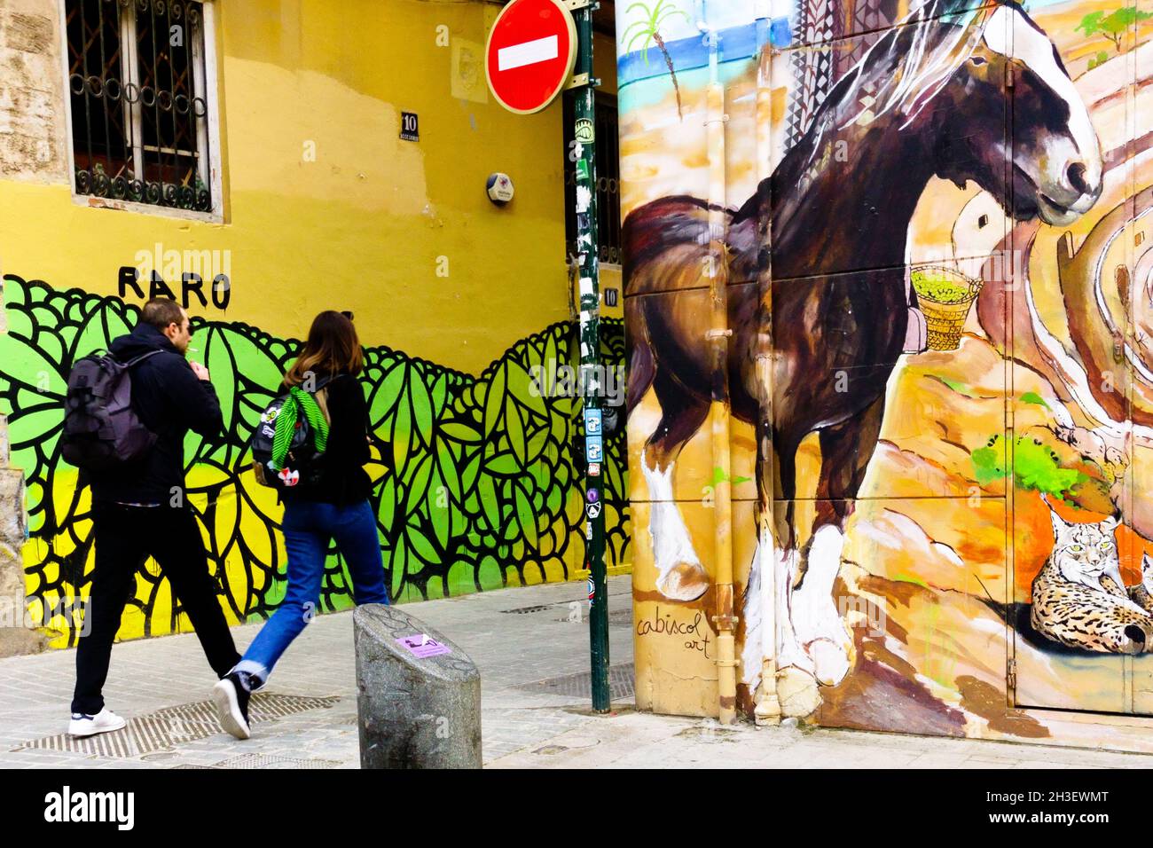 Persone che passano lungo i graffiti su un muro nel quartiere El Carmen Valencia Street art Spagna murale arte Foto Stock