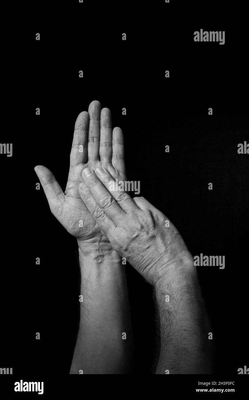 Immagine B+W drammatica del dito della mano maschile BSL inglese segno lingua lettera M isolato su sfondo scuro Foto Stock