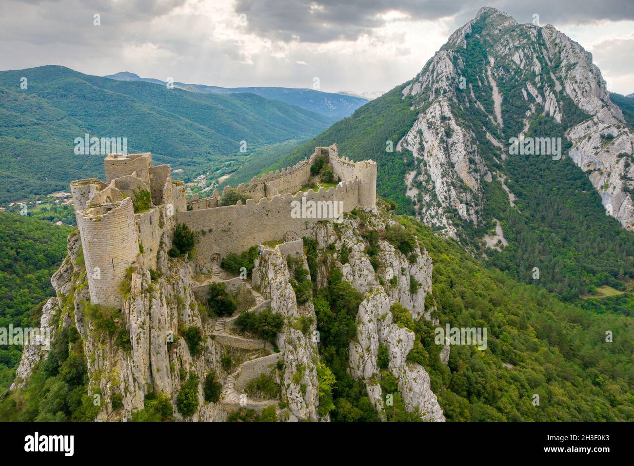 Scatto aereo che mostra il castello medievale Puilaurens e il monte Canigou nella montagna dei Pirenei, Francia Foto Stock