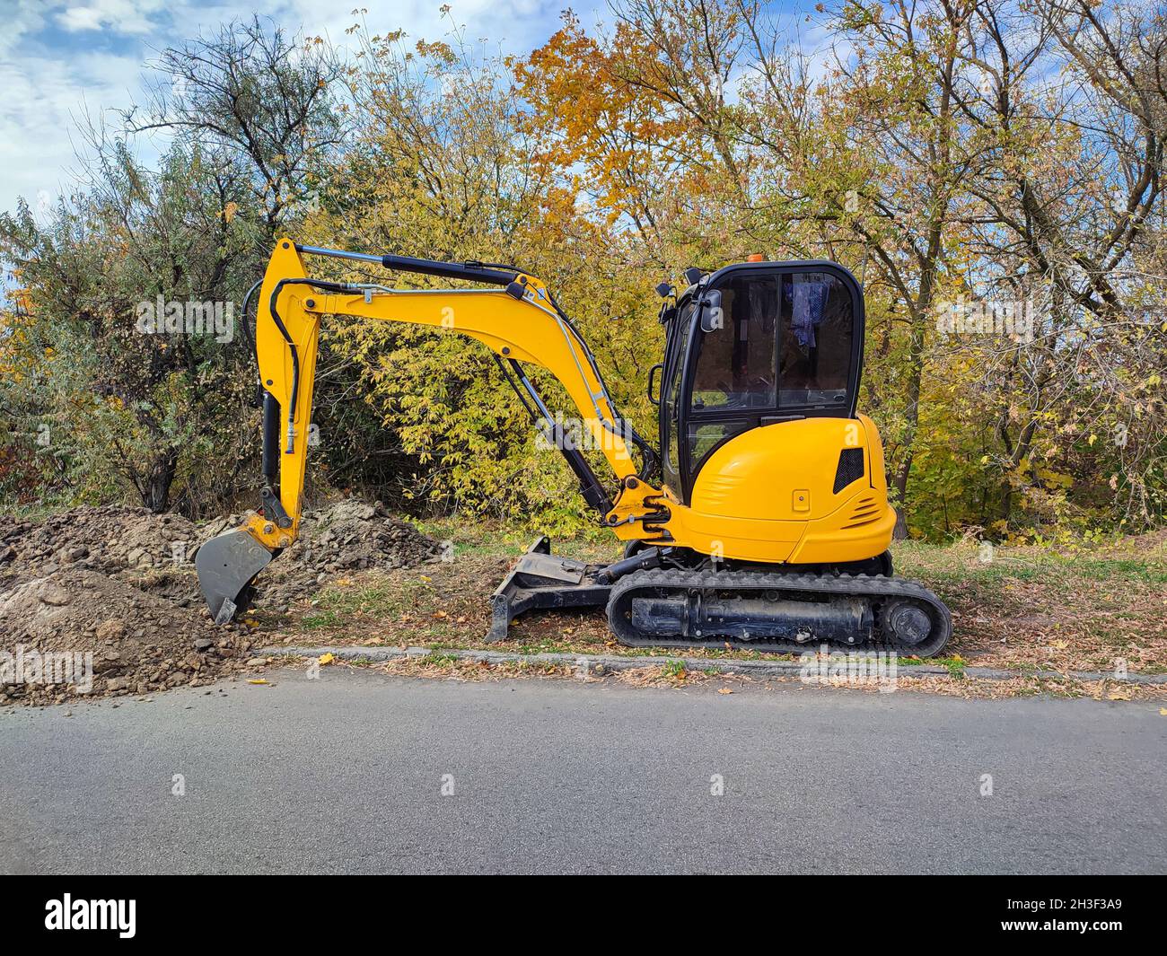 La moderna scavatrice JCB gialla o l'escavatore esegue lavori di scavo all'aperto Foto Stock