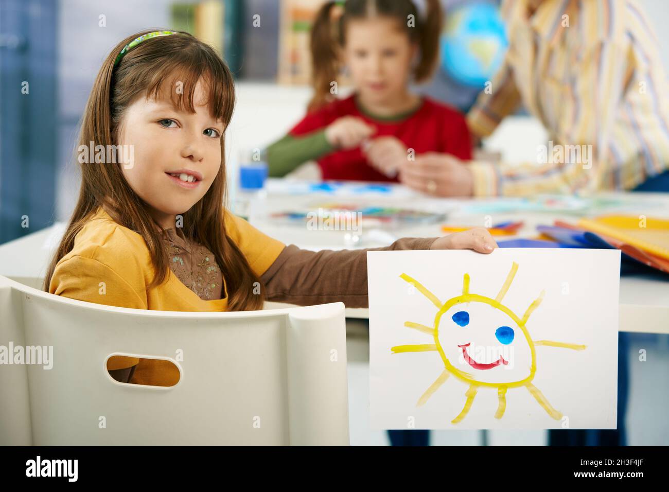 Bambina in età elementare con pittura a scuola Foto Stock
