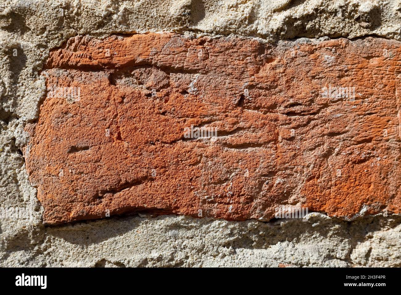 Un frammento della vecchia parete fatta di mattoni rossi Uniti con mortaio. Attualmente, l'intonaco è completamente caduto da questa parete. Foto Stock