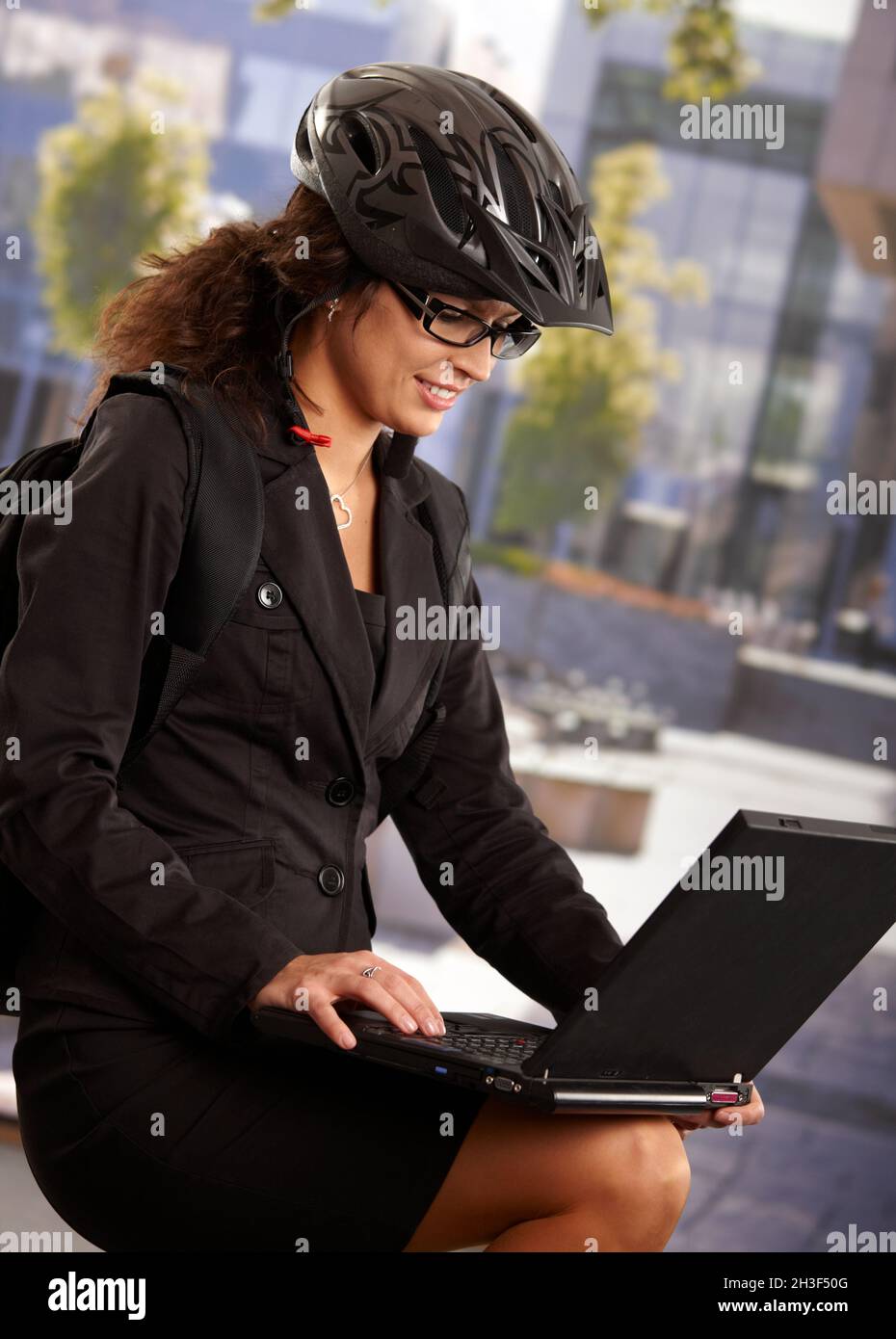 Donna d'affari che indossa casco per bicicletta Foto Stock