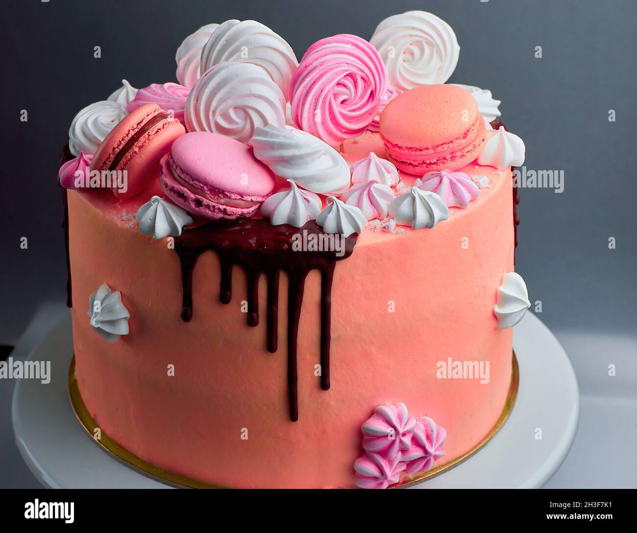 Gustosa torta rosa decorata con macaron e cioccolato Foto Stock