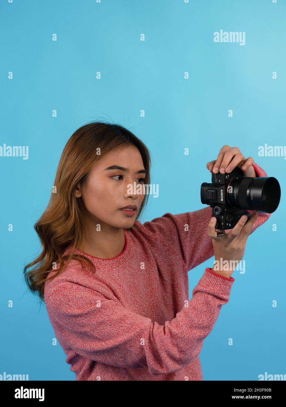 Giovane ragazza asiatica bella scattare foto con la sua macchina fotografica in studio Foto Stock