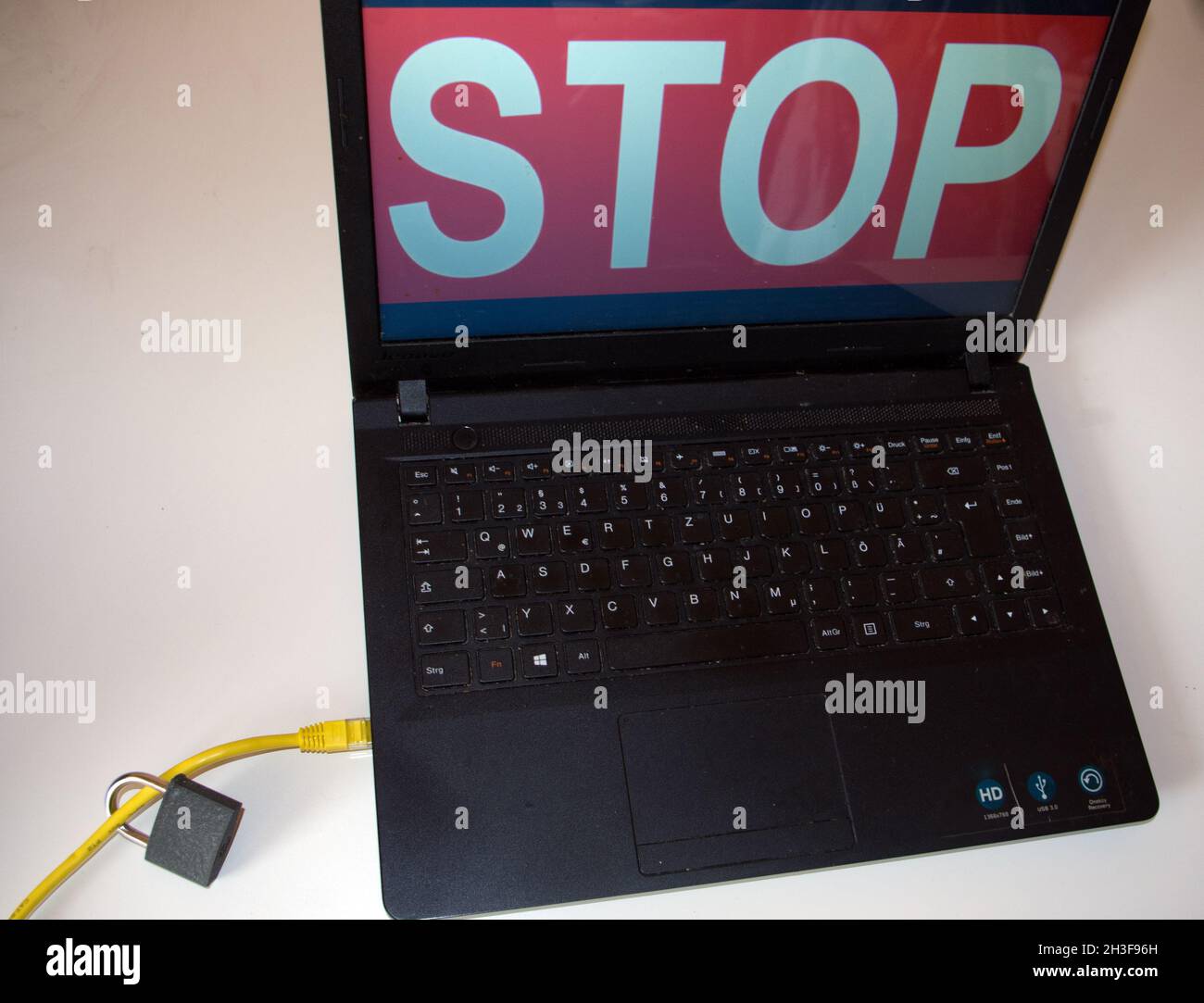 protezione internet: notebook con cavo lan e lucchetto, logo stop sullo schermo Foto Stock