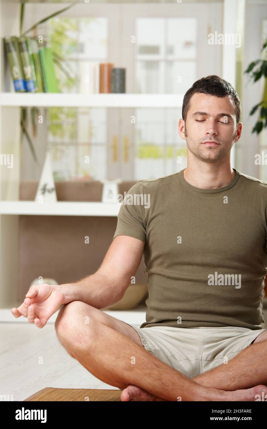 Uomo seduto in posizione di yoga Foto Stock