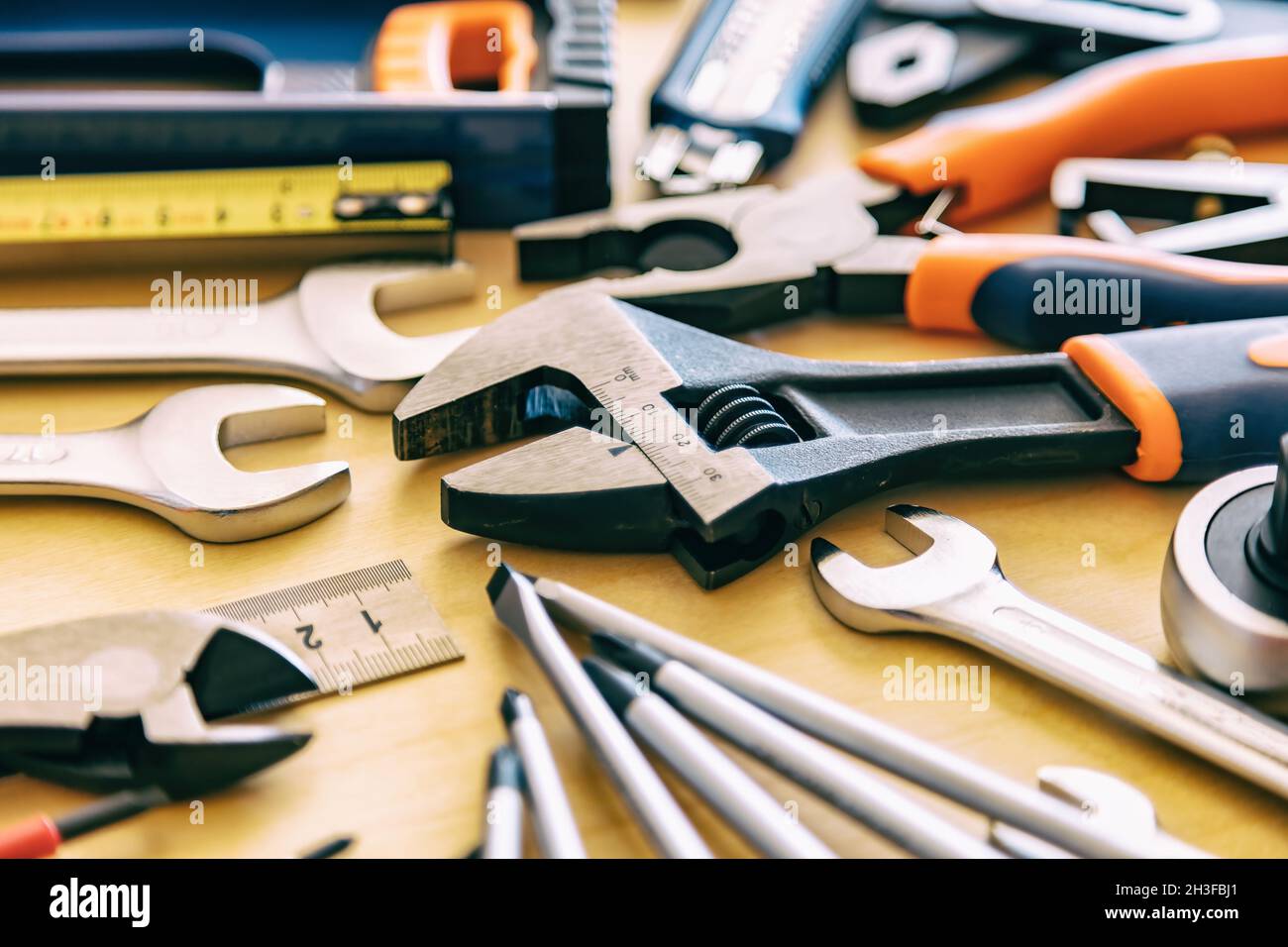 Banco d'officina. Fai da te, manutenzione lavori di posa piana. Attrezzi per riparazione in casa su sfondo in legno. Foto Stock