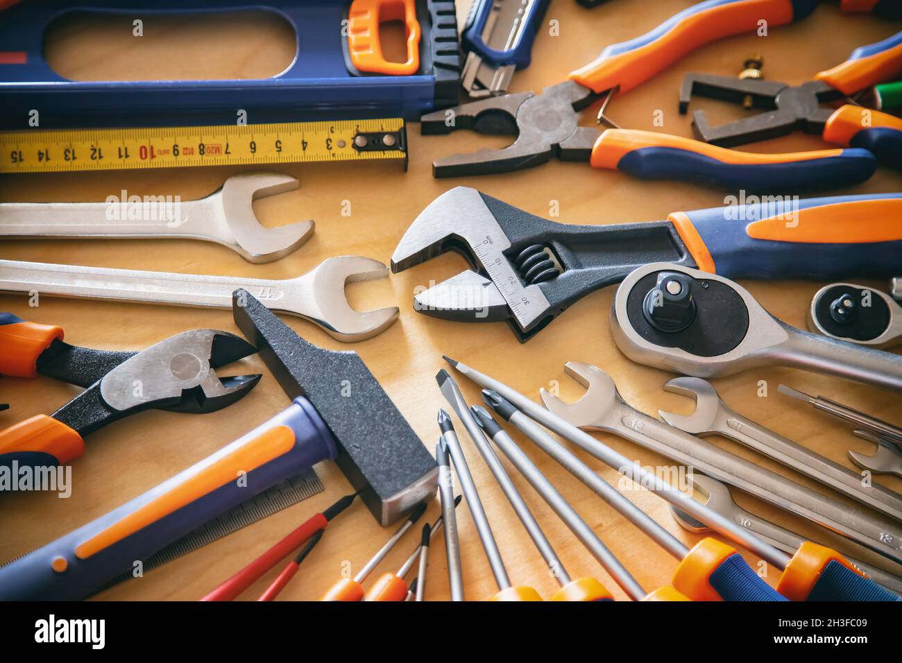 Attrezzi per riparazione in casa su sfondo in legno. Fai da te, manutenzione lavori di posa piana. Banco d'officina Foto Stock