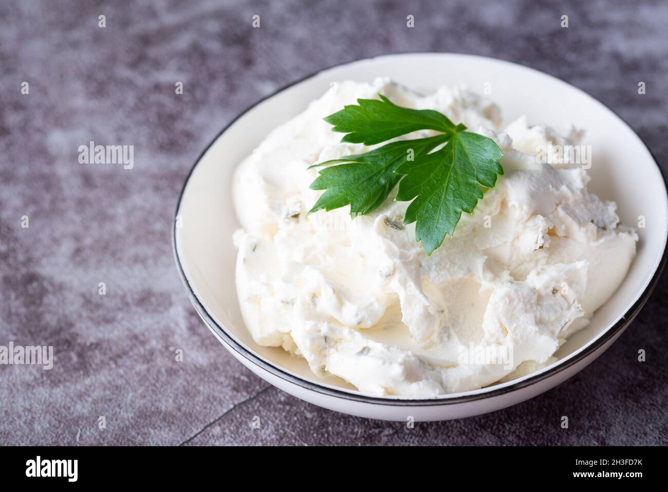 Ciotola con formaggio fresco al tavolo. Spazio per il testo Foto Stock