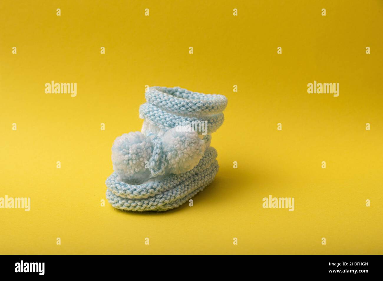 scarpe caserecce per neonati su sfondo giallo Foto Stock