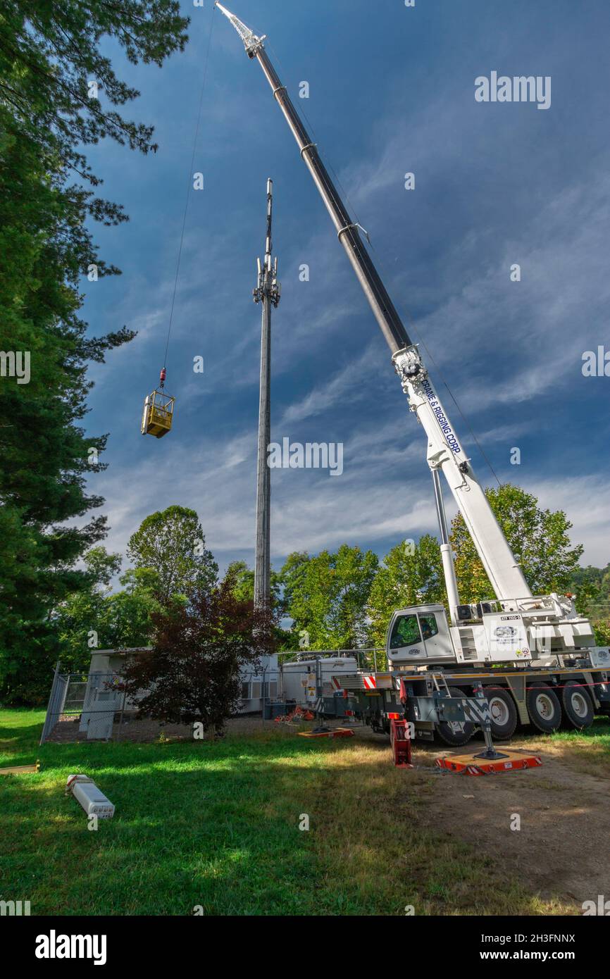 L'operatore della gru solleva con attenzione due tecnici per completare gli aggiornamenti della torre del cellulare durante le contrattazioni del Congresso sulla spesa per le infrastrutture. Foto Stock