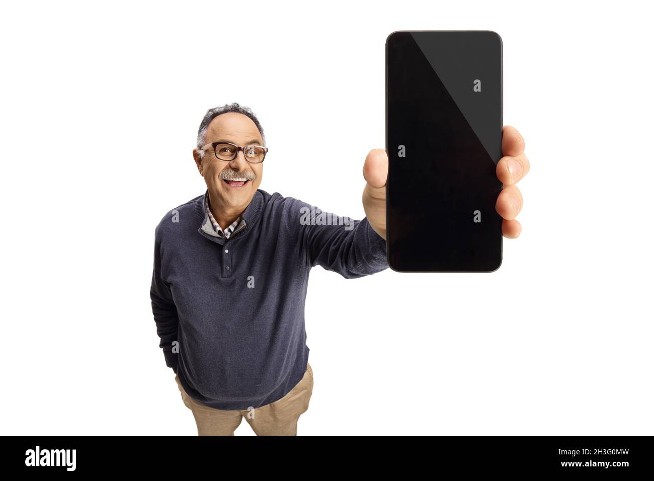 Uomo maturo sorridendo e mostrando uno smartphone di fronte alla fotocamera isolato su sfondo bianco Foto Stock