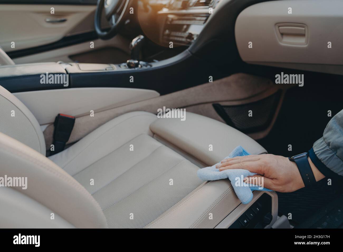 Sedile per auto in tessuto disinfettante a mano maschio con panno in microfibra Foto Stock