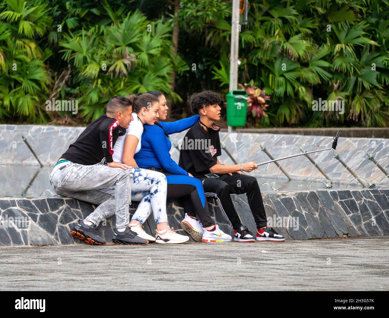 Medellin, Antioquia, Colombia - Dicembre 22 2020: Amici che prendono un selfie in una fontana in un parco pubblico Foto Stock