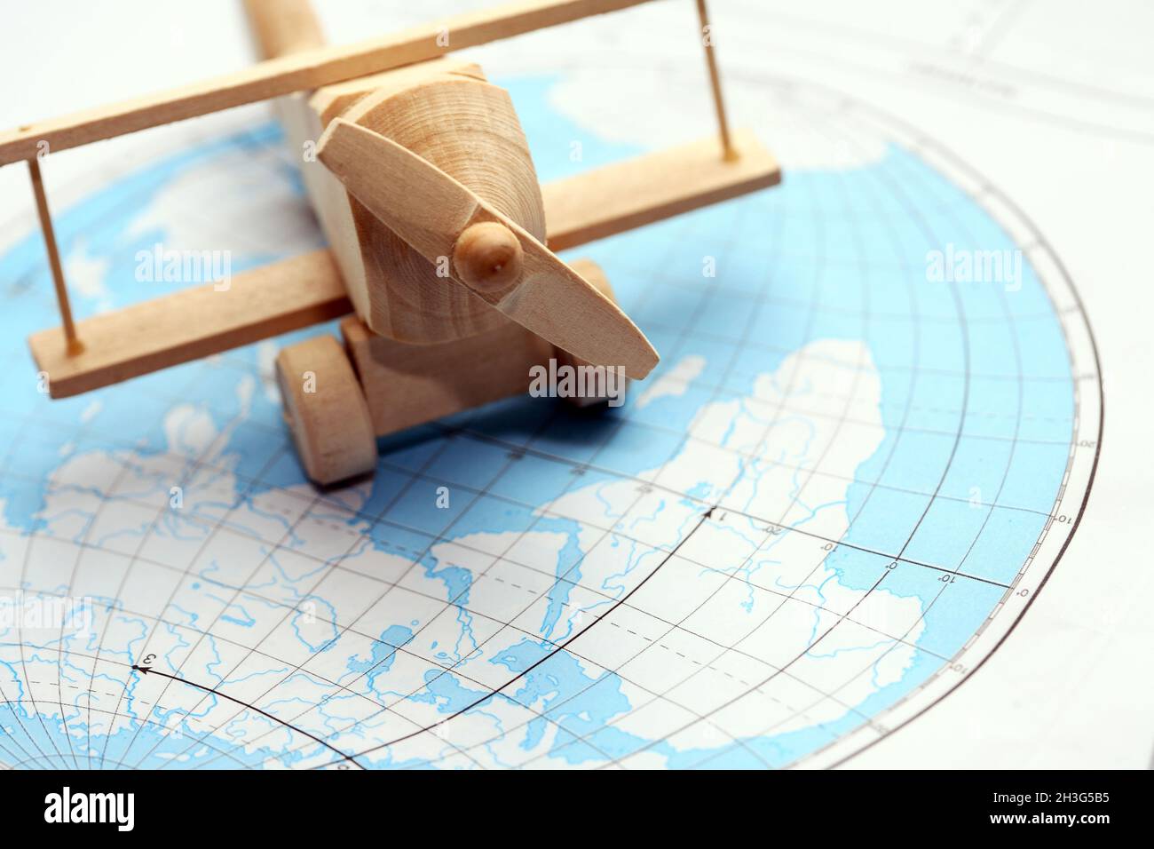 Concetto di viaggio. Piccolo aeroplano di legno sulla mappa del mondo Foto Stock