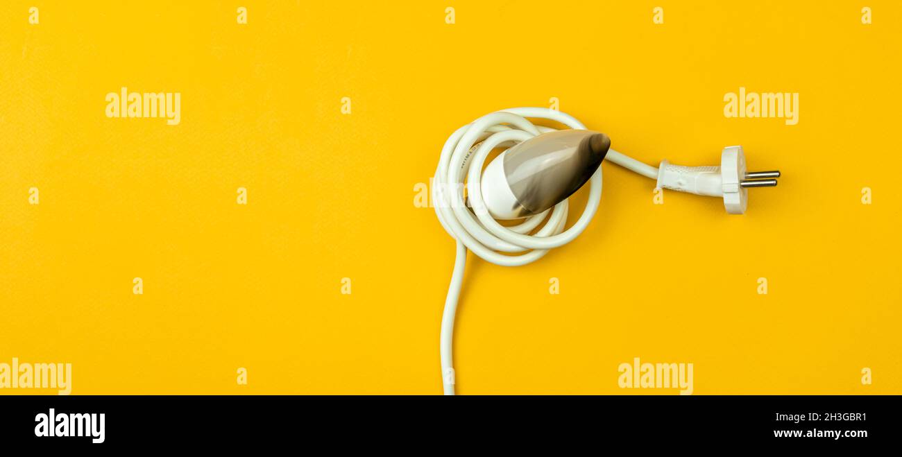 Concetto di ecologia. Lampadina a LED e cavo di alimentazione elettrica bruciati, sfondo giallo, striscione, vista dall'alto e disposizione piatta con foto dello spazio per la copia Foto Stock
