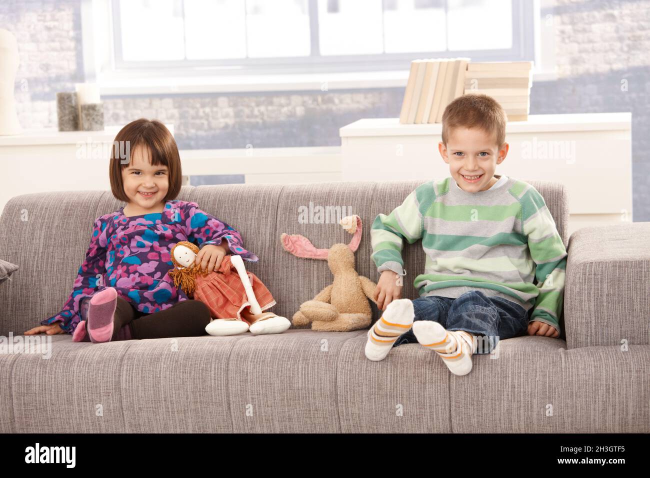 Bambini felici seduti sul divano Foto Stock