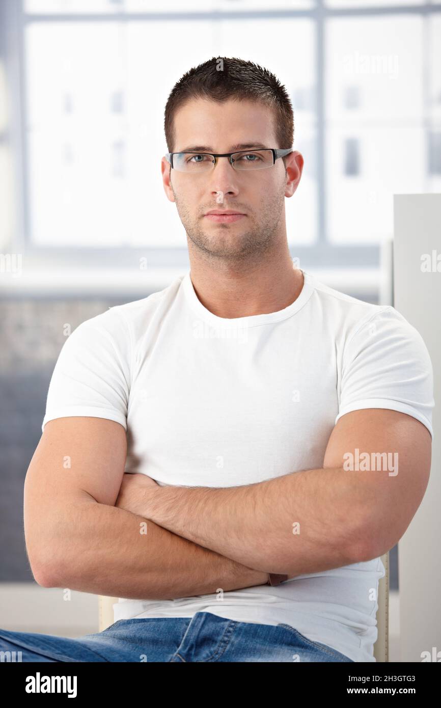 Uomo sportivo indossando occhiali da sole braccia incrociate Foto Stock