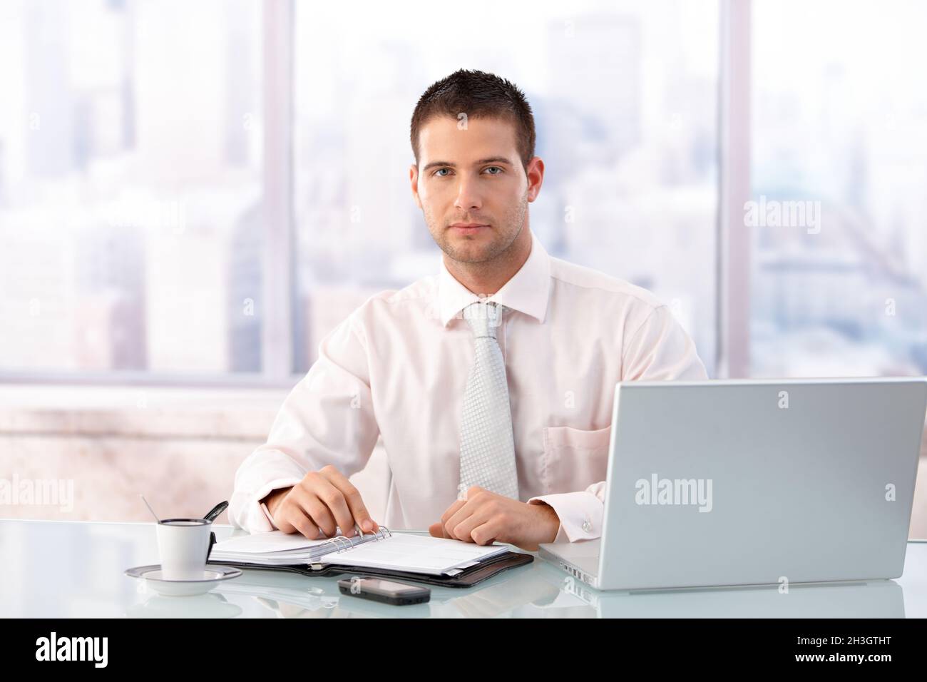 Bel uomo d'affari seduto alla scrivania in ufficio Foto Stock
