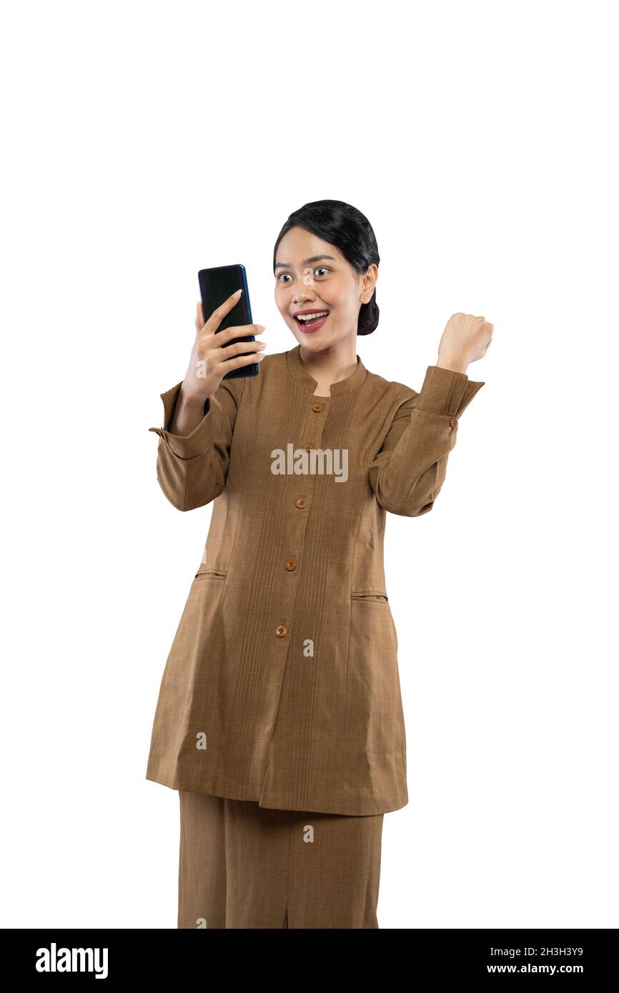 Insegnante femminile eccitata in uniforme di funzionario con le mani aggrappate Foto Stock
